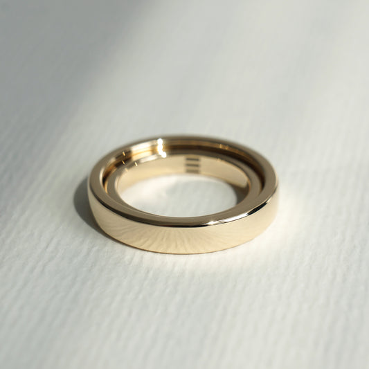 Two minimalist wedding rings in yellow gold with laser engravings.