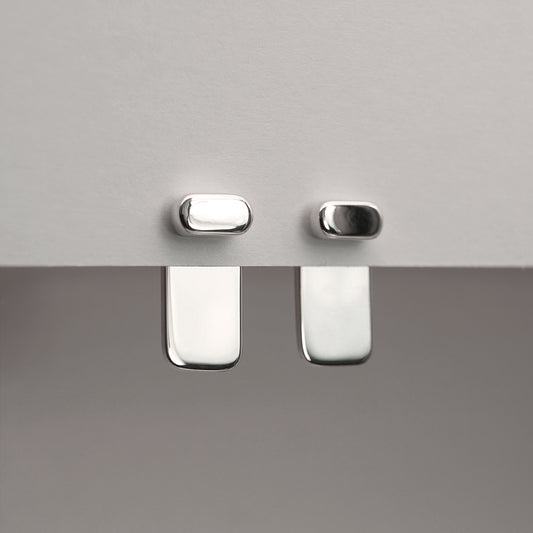 A front view of two minimalistic design silver earrings.